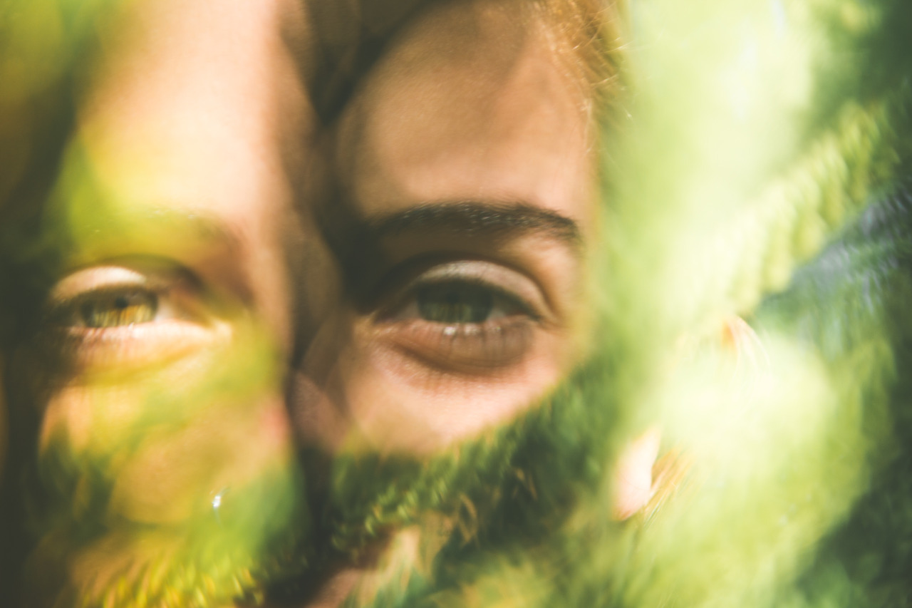 Eyes seen through green foliage