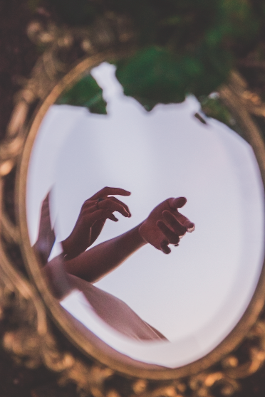 Hands reflected in an ornate mirror